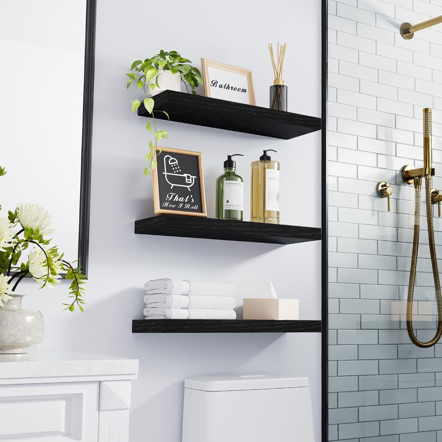 black floating shelves mounted in bathroom with plant and towels