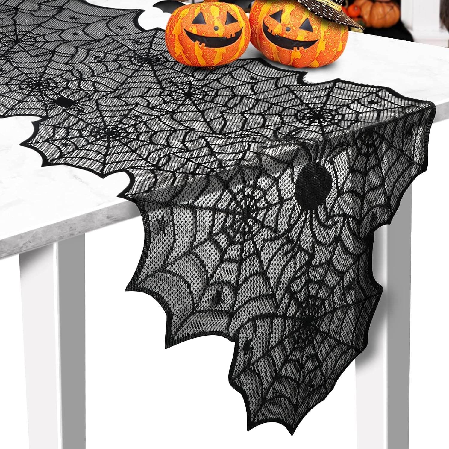 black lace spider web Halloween table runner with pumpkins on marble table