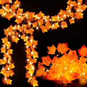 Artificial autumn maple leaf garland with warm LED string lights woven through orange and yellow leaves