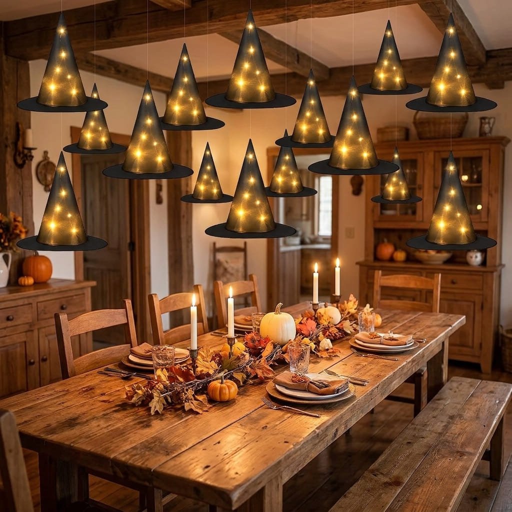 Light-up floating witch hats decor suspended above a rustic wooden dining room table with seasonal place settings