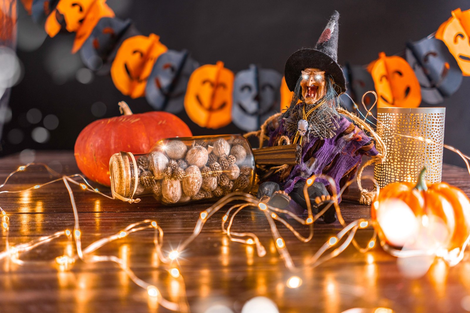 Energy Efficient Halloween Lights: The Real 92% Stat Battery Users Miss 1 Halloween tabletop display with a witch figurine with glowing eyes, a pumpkin, string lights, and a jack-o'-lantern garland